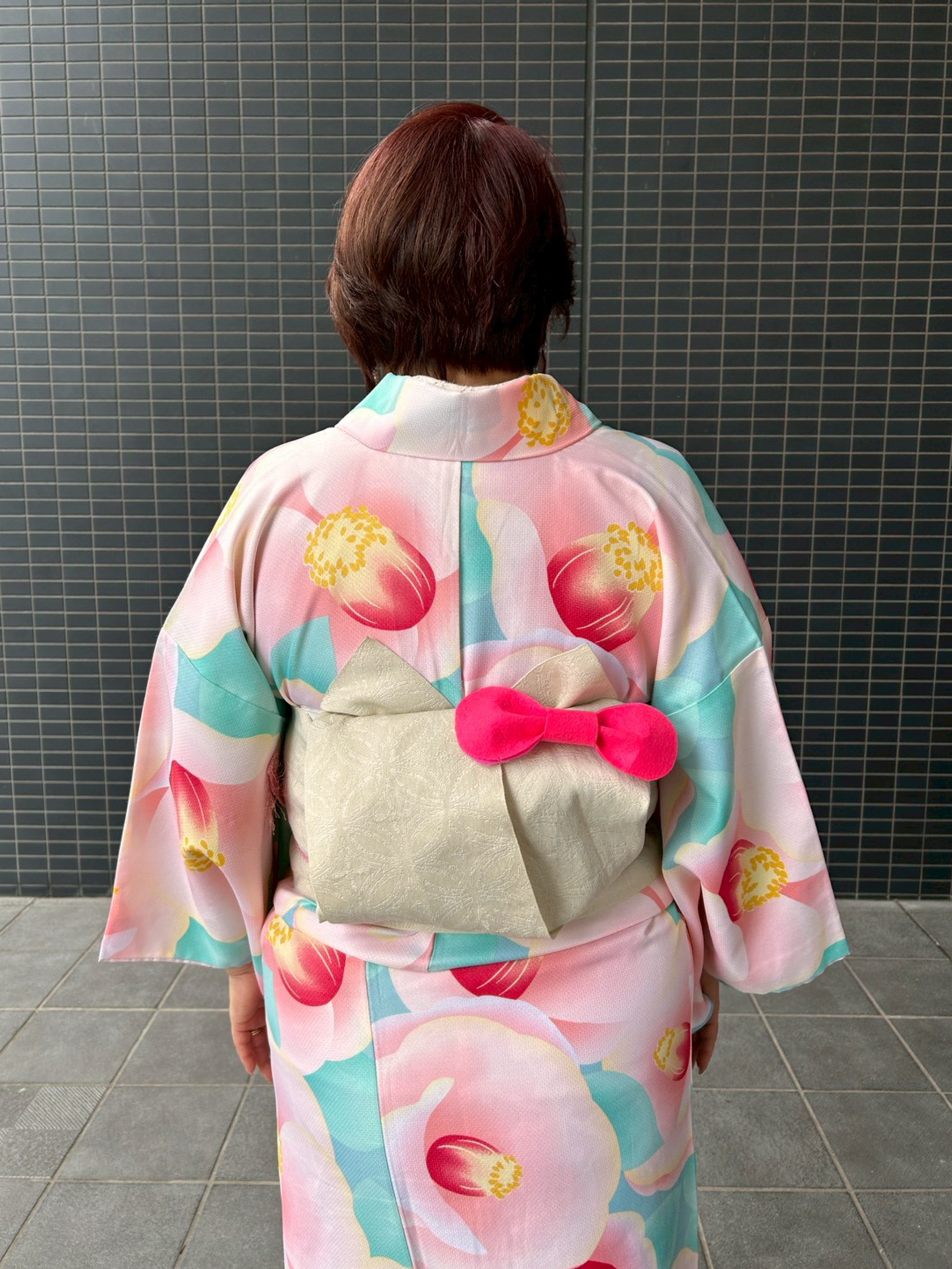 着物の帯の結び方がネコの形になっており遊び心がある着こなしをされた後ろ姿の女性